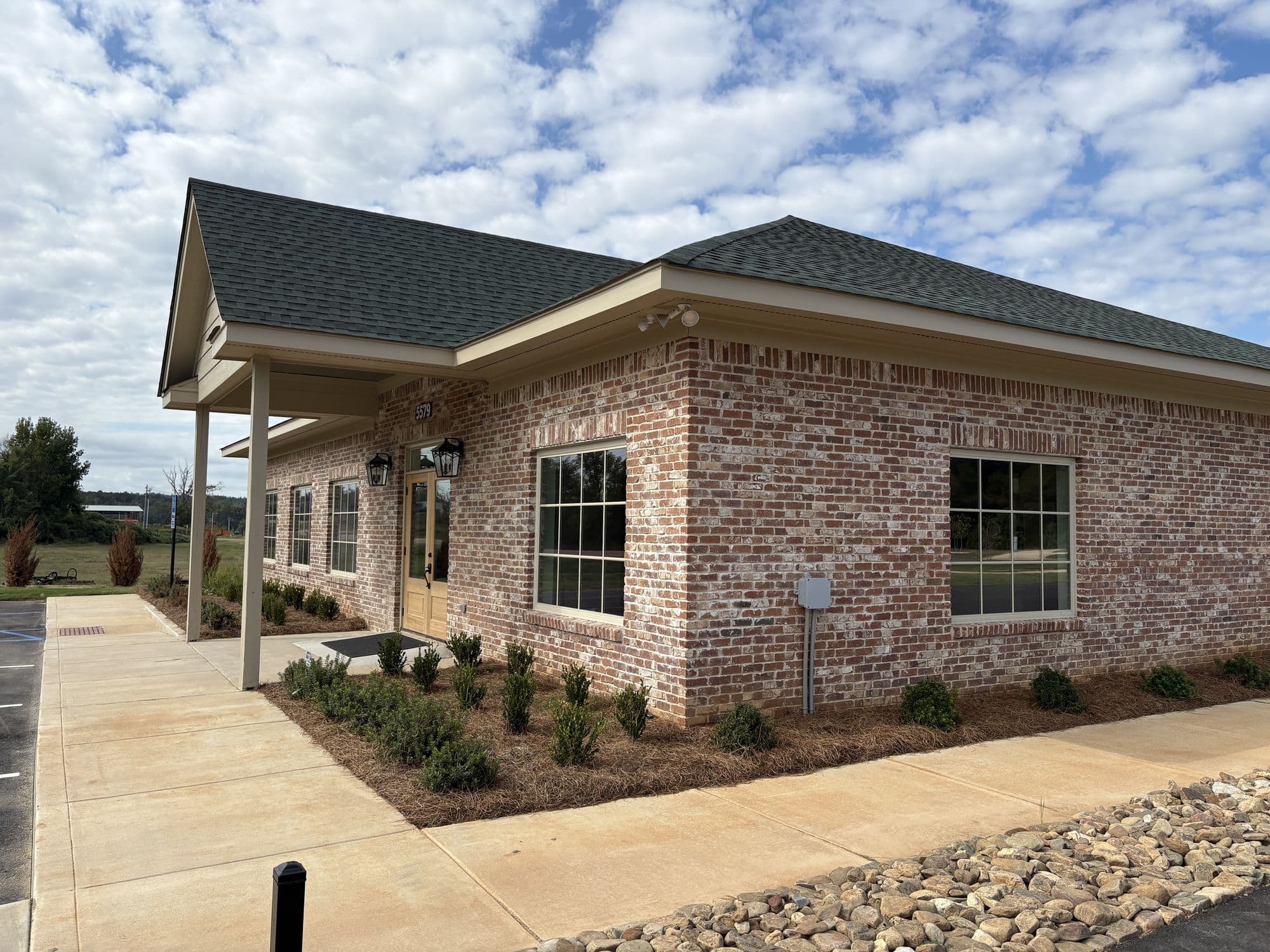 Corner of the brick park office with its covered walkway and planted beds
